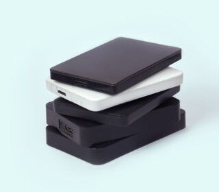 Some external hard drives for storing data, backups and security information. On light green background, isolated, copy space.